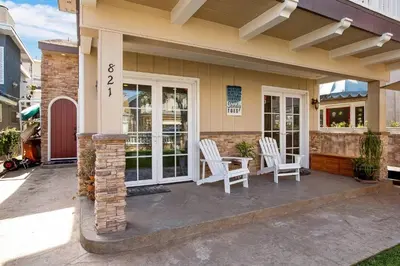 a house with two white chairs on a patio at 821 West Bay Avenue in Newport Beach