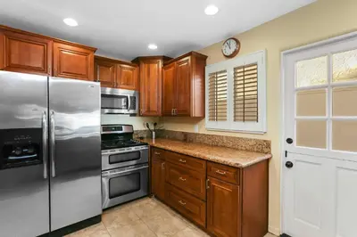 a kitchen with wooden cabinets and a stainless steel refrigerator at 821 West Bay Avenue in Newport Beach
