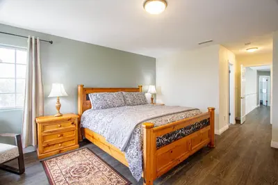a bedroom with a wooden bed and a night stand with a lamp at Casa Rosé in Temecula