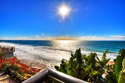a view of a beach with the sun and the ocean at Villa Bella Mare at the Retreat in Laguna Beach in Laguna Beach