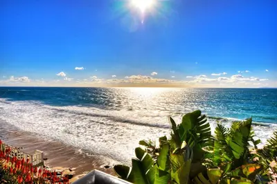 a view of a beach with the sun and the ocean at Villa Bella Mare at the Retreat in Laguna Beach in Laguna Beach
