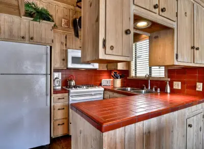a kitchen with wooden cabinets and a stainless steel refrigerator at 201 Ruby in Newport Beach