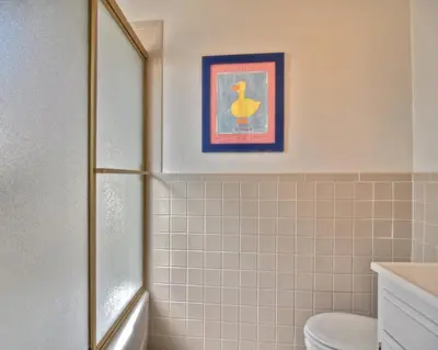 a bathroom with a toilet and a picture of a duck at 201 Ruby in Newport Beach