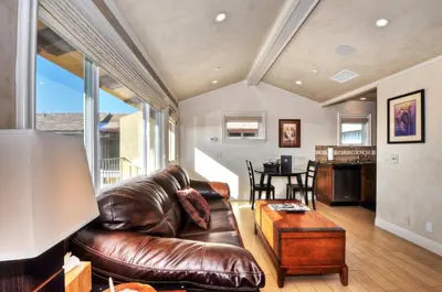 a living room with a leather couch and a table at Villa D'Arte at the Retreat in Laguna Beach in Laguna Beach