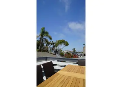 a view from the balcony of a house with a wooden table at 313 E Bay Ave B in Newport Beach