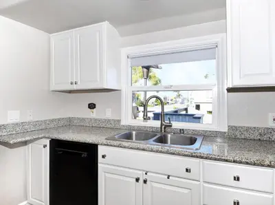 a kitchen with white cabinets and a sink and a window at 313 E Bay Ave B in Newport Beach