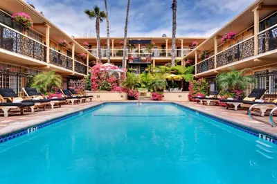 a pool at a hotel with chairs and flowers at Villa Da Vinci at the Retreat at Laguna Beach in Laguna Beach