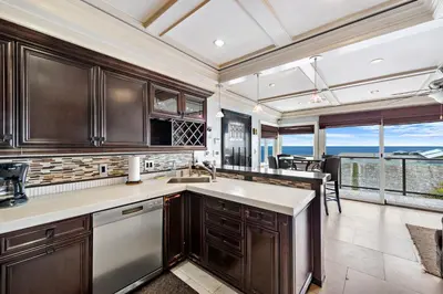 a kitchen with wooden cabinets and a view of the ocean at Villa Da Vinci at the Retreat at Laguna Beach in Laguna Beach