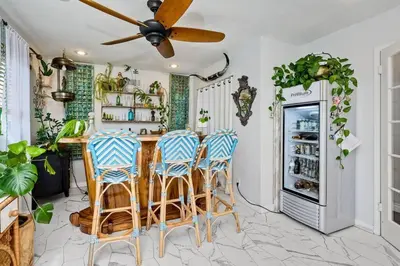 a kitchen with a bar with stools and a refrigerator at Your Private Resort near Coast in Oceanside