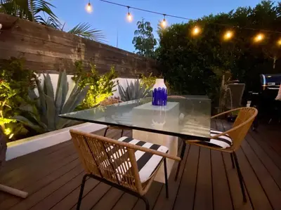 a glass table and chairs on a deck at night at Your Private Resort near Coast in Oceanside