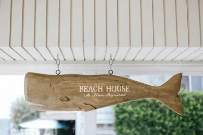 a sign that reads beach house at a beach paradise at 1400 S Bayfront in Newport Beach