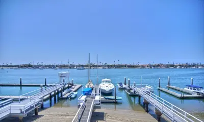 a group of boats docked at a dock at 1005 E Balboa 2 in Newport Beach