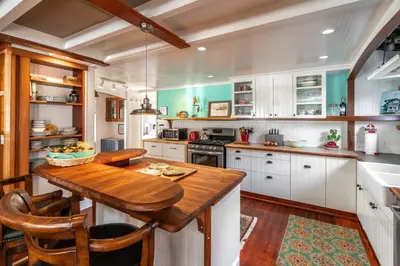 a kitchen with white cabinets and a wooden table at 318 Lindo Ave in Newport Beach