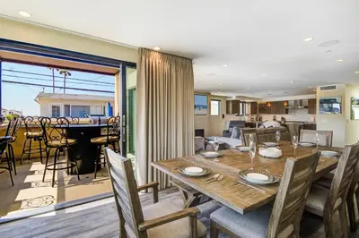 a dining room and living room with a table and chairs at 209 9th St in Newport Beach