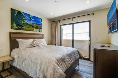 a bedroom with a large bed and a large window at 209 9th St in Newport Beach