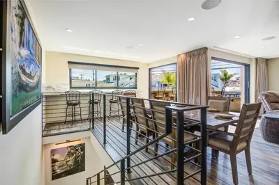 a room with a balcony with a table and chairs at 209 9th St in Newport Beach