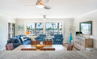 a living room with a couch and a table and chairs at 600 E Oceanfront 2B in Newport Beach