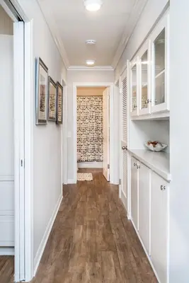 a hallway of a home with white walls and wood floors at 600 E Oceanfront 2B in Newport Beach