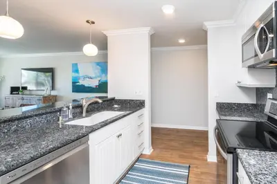 a kitchen with white cabinets and a sink at 600 E Oceanfront 2B in Newport Beach