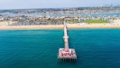 a pier in the water next to a beach at 600 E Oceanfront 2B in Newport Beach