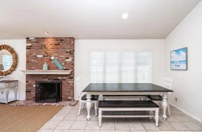 a dining room with a table and a fireplace at 210 Opal Ave Front House in Newport Beach