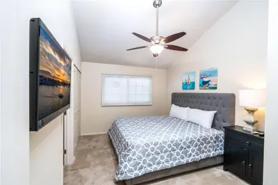 a bedroom with a bed and a flat screen tv at 210 Opal Ave Front House in Newport Beach