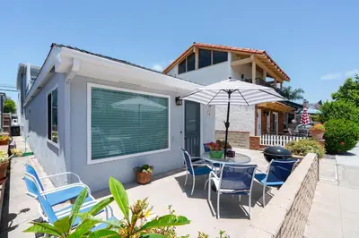 a patio with a table and chairs and an umbrella at 129 Opal Ave A in Newport Beach