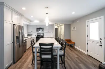 a kitchen with white cabinets and a table and chairs at 129 Opal Ave A in Newport Beach