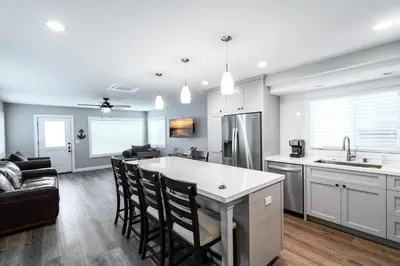 a kitchen and living room with white cabinets and a kitchen island at 129 Opal Ave A in Newport Beach