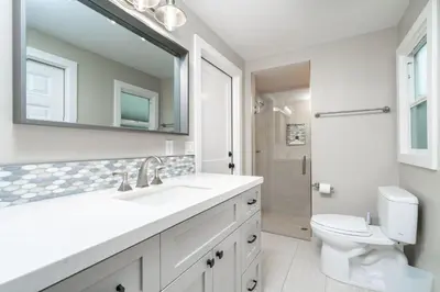 a white bathroom with a sink and a toilet at 129 Opal Ave A in Newport Beach