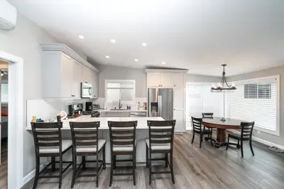 a kitchen with a table and chairs and a kitchen with white cabinets at 129 Opal Ave A & B in Newport Beach