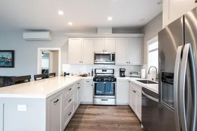 a kitchen with white cabinets and stainless steel appliances at 129 Opal Ave A & B in Newport Beach