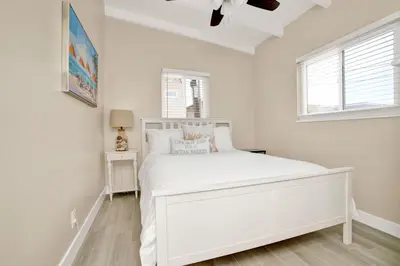 a white bedroom with a white bed and a window at 114 Forty Second Street B in Newport Beach