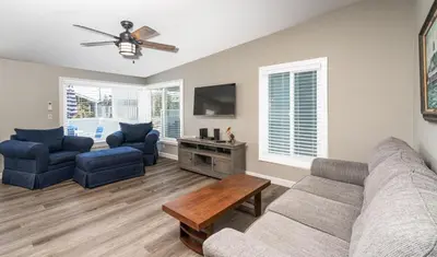 a living room with a couch and chairs and a tv at 129 Opal Ave B in Newport Beach