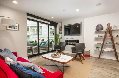 a living room with a red couch and chairs at Pier to Pier in Newport Beach