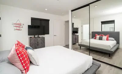 a bedroom with two beds and a mirror at Pier to Pier in Newport Beach