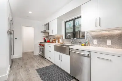 a kitchen with white cabinets and stainless steel appliances at Pier to Pier in Newport Beach