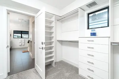 a walk in closet with white cabinets and a window at Pier to Pier in Newport Beach