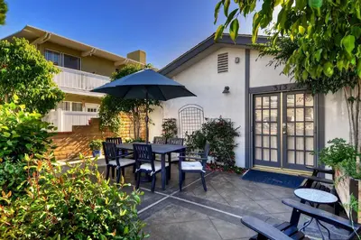 a patio with a table and chairs and an umbrella at 313 E Bay Ave A in Newport Beach