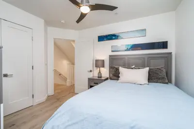 a bedroom with a bed and a ceiling fan at Upper West Newport in Newport Beach