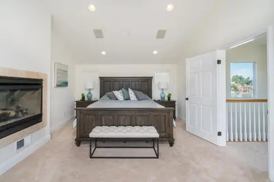 a bedroom with a large bed and a fireplace at 310 and a half Iris Ave in Newport Beach