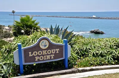 a sign for a lookout point in front of the ocean at 310 and a half Iris Ave in Newport Beach