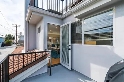 a balcony of a house with a door and a patio at 310 and a half Iris Ave in Newport Beach