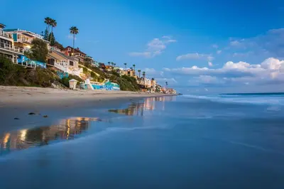 a beach with houses and palm trees and the ocean at Villa Leone at the Retreat in Laguna Beach in Laguna Beach