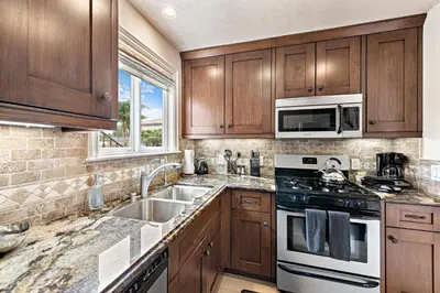 a kitchen with wooden cabinets and a stove top oven at Villa Rustico at the Retreat in Laguna Beach in Laguna Beach