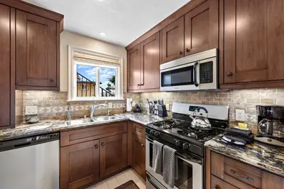 a kitchen with wooden cabinets and a stove top oven at Villa Rustico at the Retreat in Laguna Beach in Laguna Beach