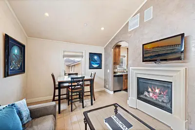 a living room with a fireplace and a table at Villa Teatro at the Retreat in Laguna Beach in Laguna Beach