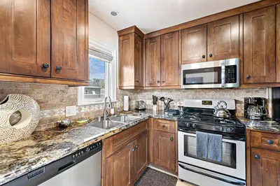 a kitchen with wooden cabinets and a stove top oven at Villa Teatro at the Retreat in Laguna Beach in Laguna Beach