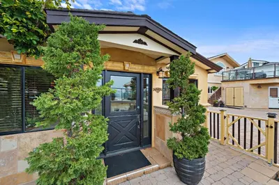 a house with a black door and two trees at Villa Palazzo D'Stella at the Retreat in Laguna Beach
