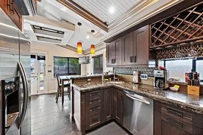 a kitchen with wooden cabinets and stainless steel appliances at Villa Palazzo D'Stella at the Retreat in Laguna Beach